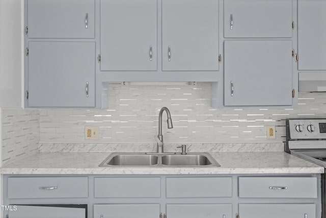 kitchen with stove, tasteful backsplash, and sink