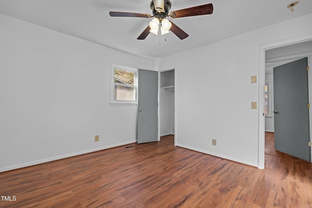 unfurnished bedroom with a closet, ceiling fan, and dark hardwood / wood-style flooring