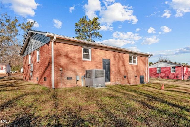 rear view of property featuring a lawn and cooling unit