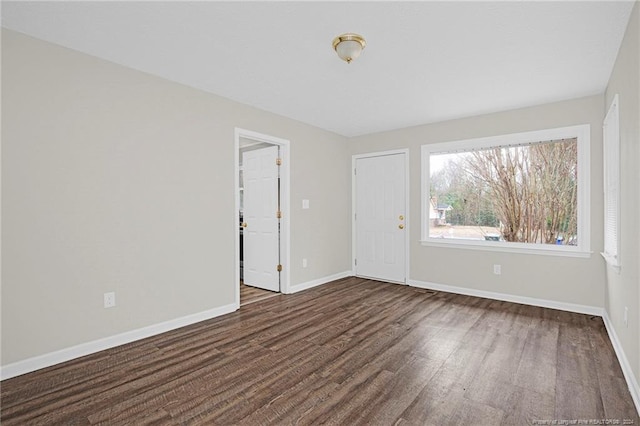 empty room with dark hardwood / wood-style flooring