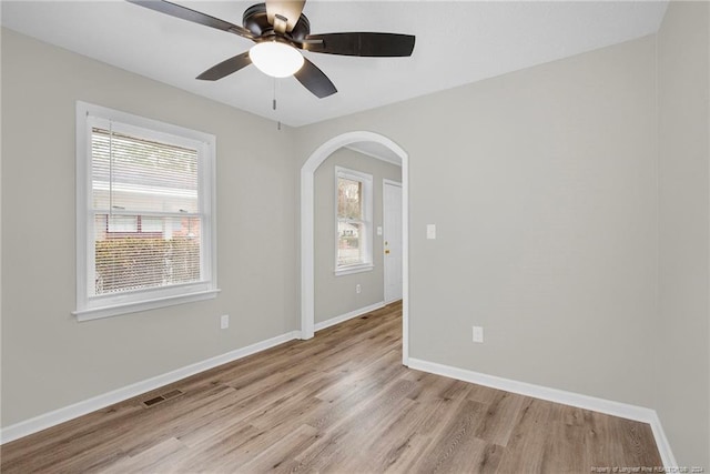 empty room with ceiling fan and light hardwood / wood-style floors