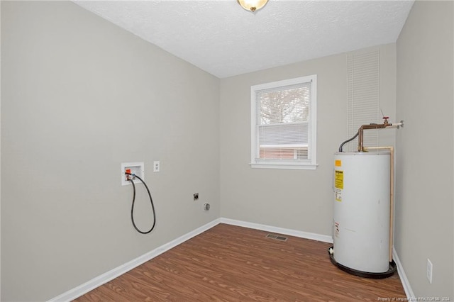 clothes washing area featuring washer hookup, hookup for an electric dryer, water heater, a textured ceiling, and hardwood / wood-style flooring