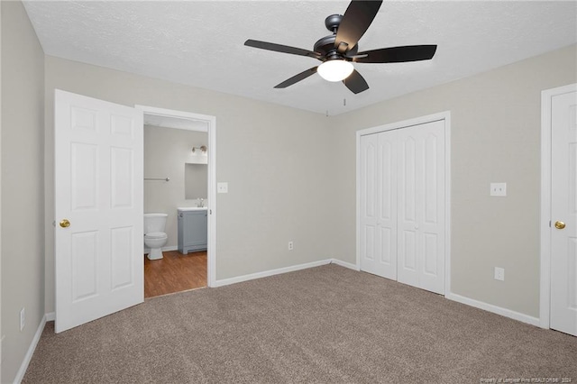 unfurnished bedroom with ceiling fan, carpet floors, connected bathroom, and a closet