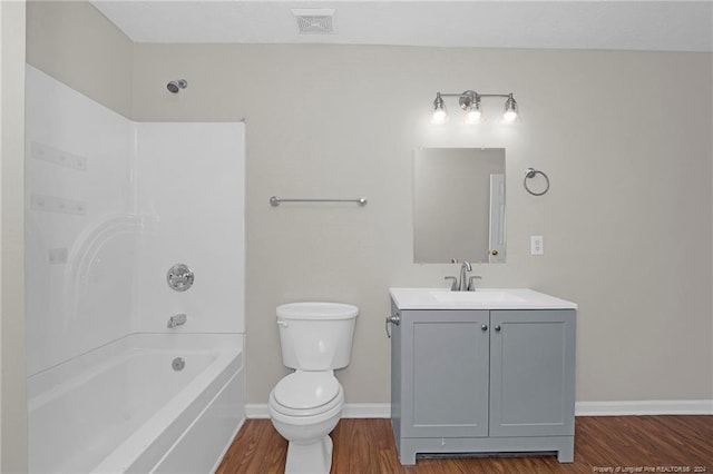 full bathroom featuring hardwood / wood-style flooring, vanity, toilet, and tub / shower combination