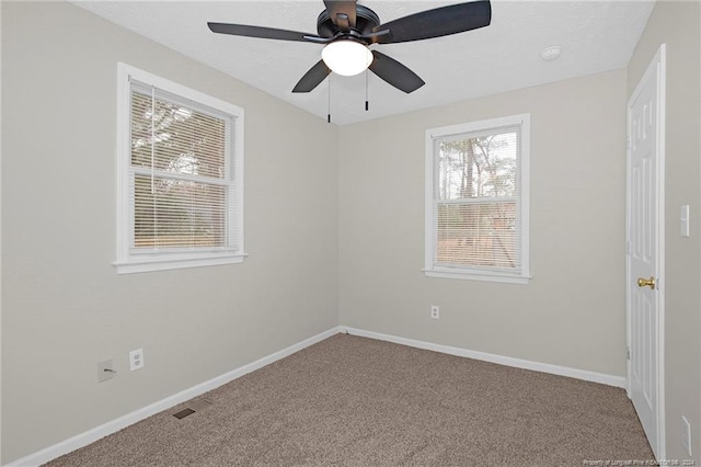 carpeted spare room featuring ceiling fan