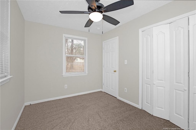 unfurnished bedroom featuring carpet, ceiling fan, and a closet