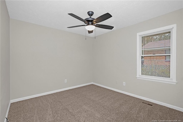 empty room featuring carpet, ceiling fan, and a textured ceiling