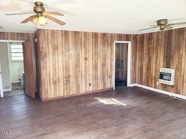 unfurnished room featuring heating unit, wooden walls, and dark hardwood / wood-style flooring