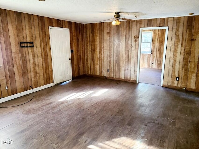 empty room with a textured ceiling, dark hardwood / wood-style flooring, and ceiling fan