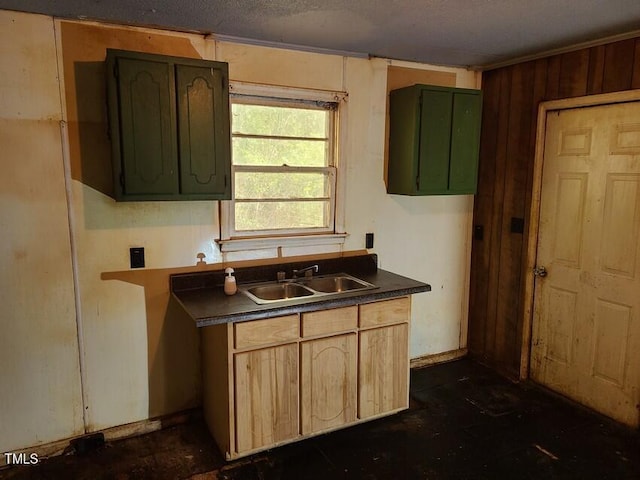 kitchen featuring a textured ceiling, wooden walls, sink, and light brown cabinetry