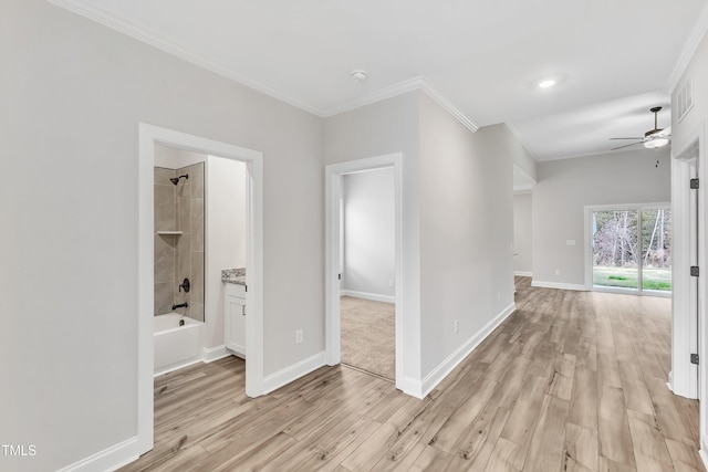 hallway with crown molding and light hardwood / wood-style flooring