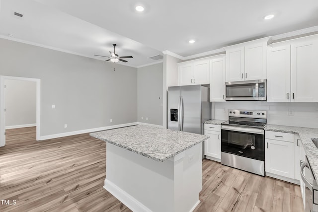 kitchen with white cabinets, stainless steel appliances, a kitchen island, and ceiling fan