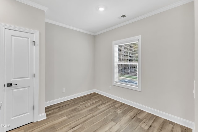 spare room with light wood-type flooring and ornamental molding