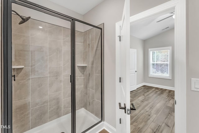 bathroom with hardwood / wood-style flooring, walk in shower, lofted ceiling, and ceiling fan