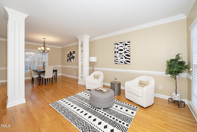 living room with hardwood / wood-style floors, decorative columns, crown molding, and an inviting chandelier