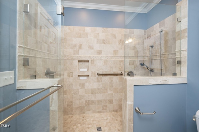 bathroom featuring tiled shower, toilet, and crown molding