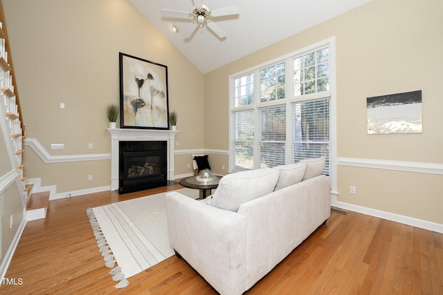 living room with light hardwood / wood-style floors, ceiling fan, and lofted ceiling