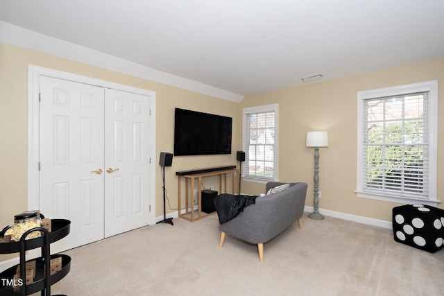 living area with light carpet, a healthy amount of sunlight, and lofted ceiling