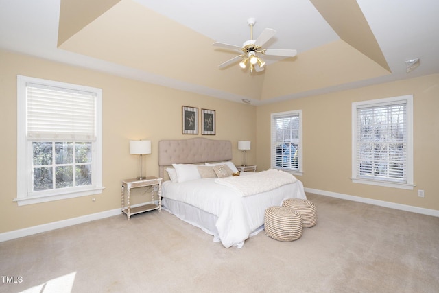 bedroom with a tray ceiling, ceiling fan, and light colored carpet