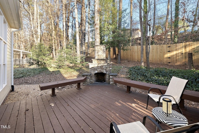 wooden terrace featuring an outdoor stone fireplace