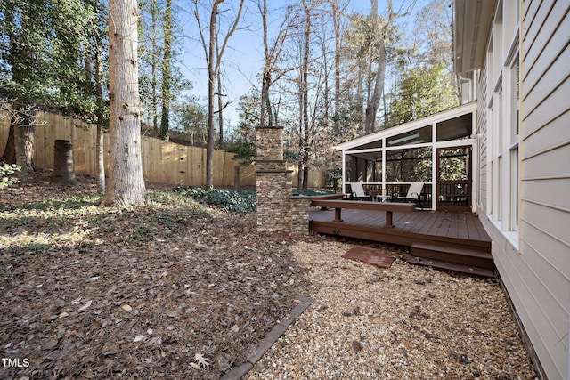 view of yard featuring a wooden deck and a sunroom