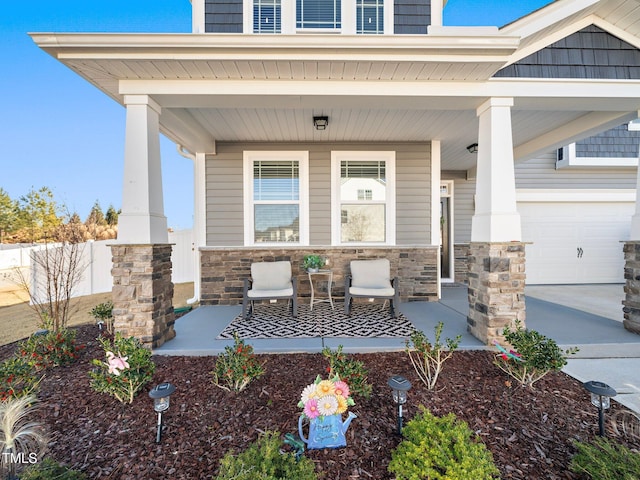 entrance to property featuring a porch and a garage