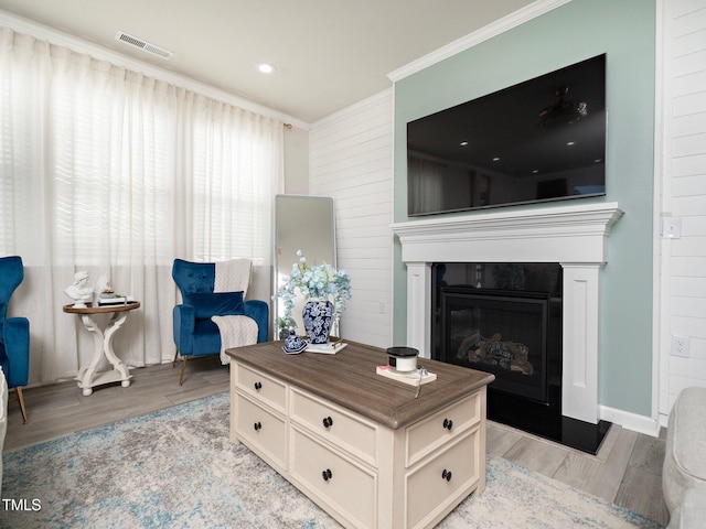 living room featuring light hardwood / wood-style floors and ornamental molding