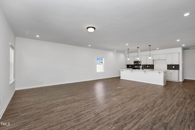 unfurnished living room featuring dark hardwood / wood-style flooring and sink