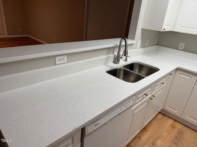 kitchen with white cabinets, dishwasher, light hardwood / wood-style floors, and sink