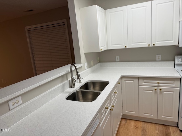 kitchen with dishwasher, light hardwood / wood-style flooring, white cabinetry, and sink