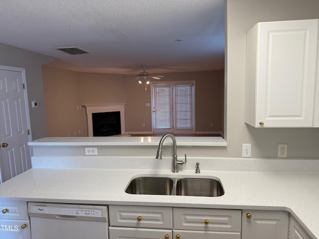 kitchen featuring white dishwasher, sink, ceiling fan, a textured ceiling, and white cabinetry