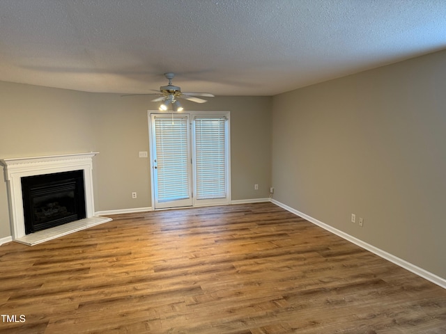 unfurnished living room featuring hardwood / wood-style floors, ceiling fan, and a textured ceiling