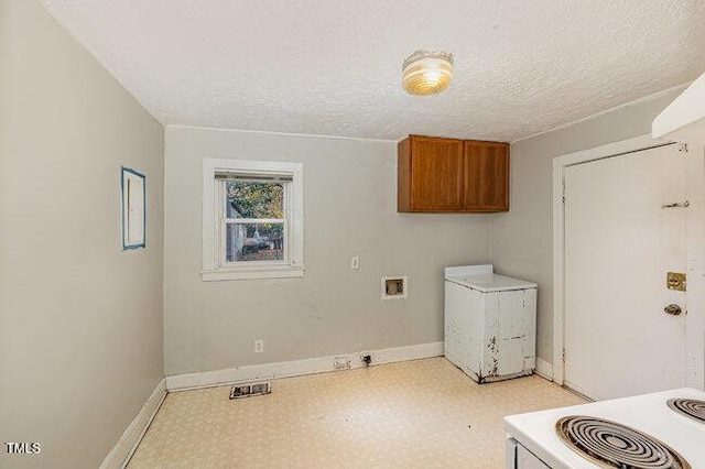 laundry area with cabinets, washer hookup, and a textured ceiling