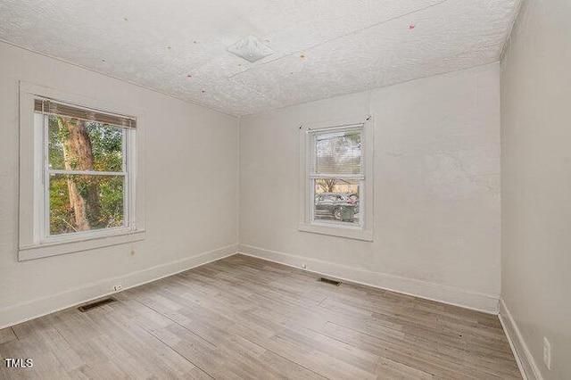 empty room featuring wood-type flooring and a textured ceiling