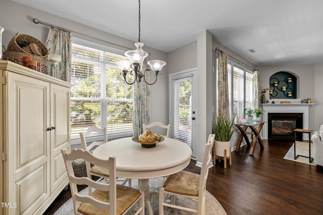 dining area with dark hardwood / wood-style flooring and a notable chandelier