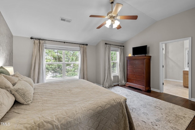 bedroom featuring ceiling fan, lofted ceiling, dark wood-type flooring, and ensuite bath