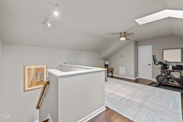 bonus room featuring dark hardwood / wood-style floors, lofted ceiling with skylight, and ceiling fan