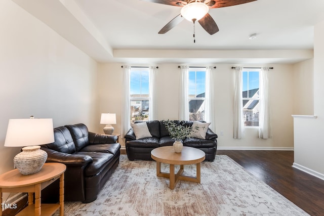 living room with dark hardwood / wood-style flooring and ceiling fan