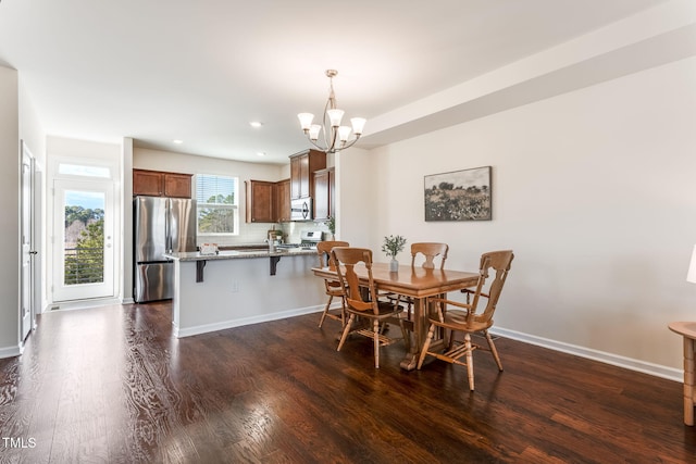 dining space with dark wood-type flooring and a chandelier