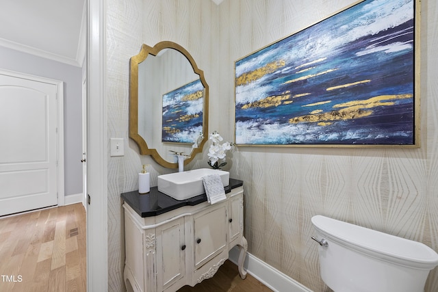 bathroom featuring toilet, vanity, ornamental molding, and hardwood / wood-style flooring