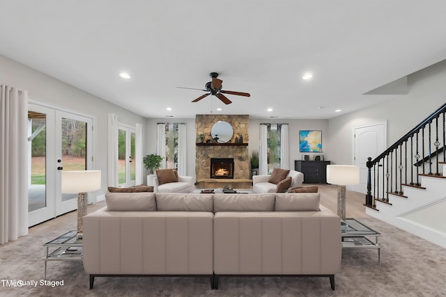 living room featuring ceiling fan, carpet, french doors, and a fireplace