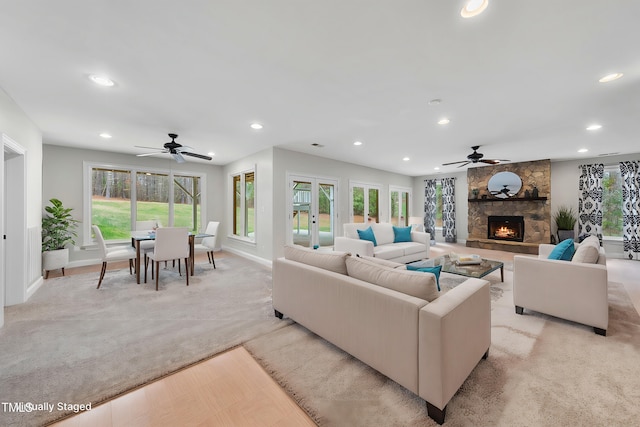 living room with ceiling fan, light wood-type flooring, and a fireplace