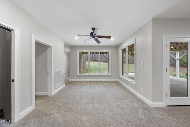 spare room with ceiling fan and light colored carpet