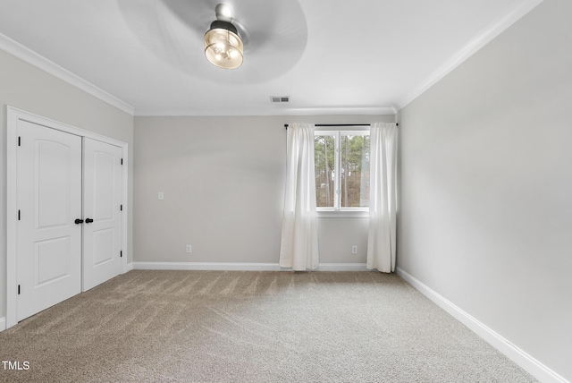 unfurnished bedroom with ceiling fan, a closet, ornamental molding, and carpet flooring