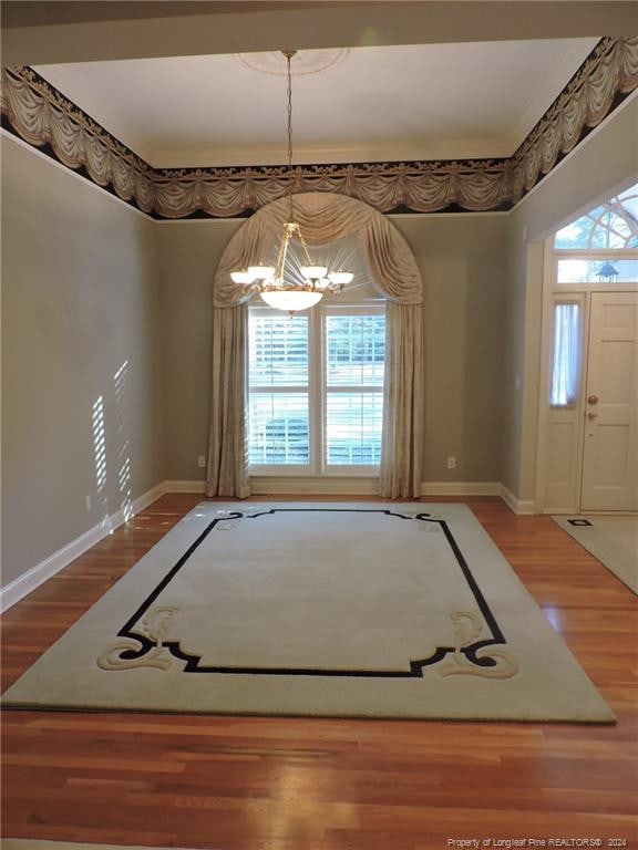 unfurnished dining area with wood-type flooring and an inviting chandelier