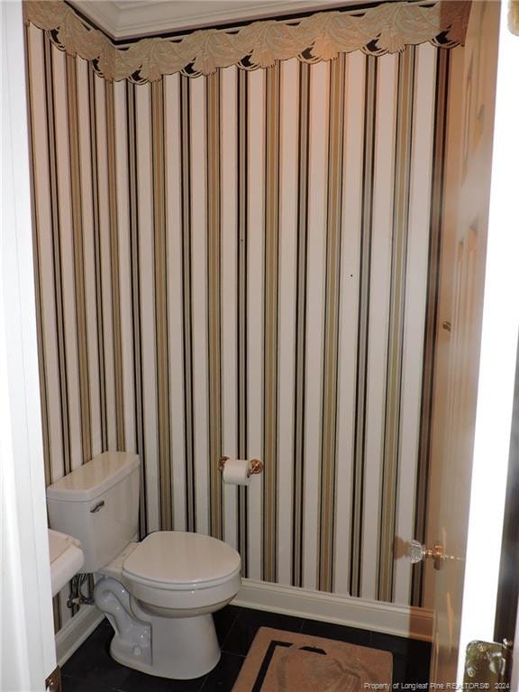 bathroom featuring tile patterned flooring, toilet, and crown molding