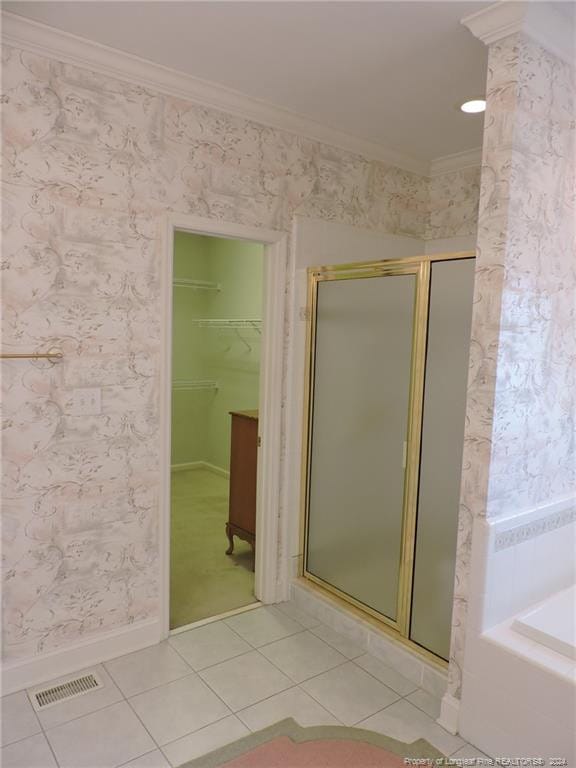 bathroom featuring tile patterned floors, a shower with shower door, and crown molding