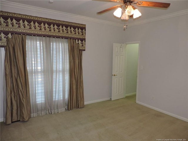 carpeted spare room featuring ceiling fan and ornamental molding