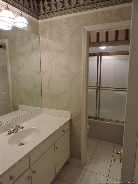 bathroom with tile patterned floors, vanity, and shower / bath combination with glass door