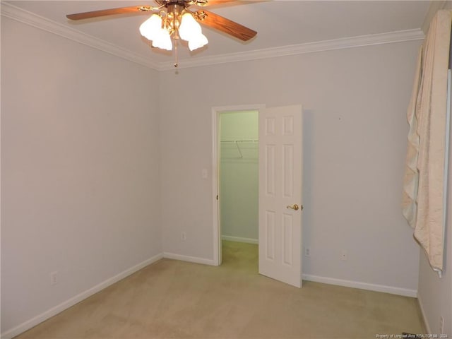 unfurnished bedroom with ceiling fan, light colored carpet, ornamental molding, and a closet